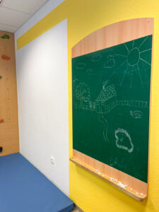 Therapieraum in der Ergotherapie Uchte mit einer grünen Tafel zum Schreiben